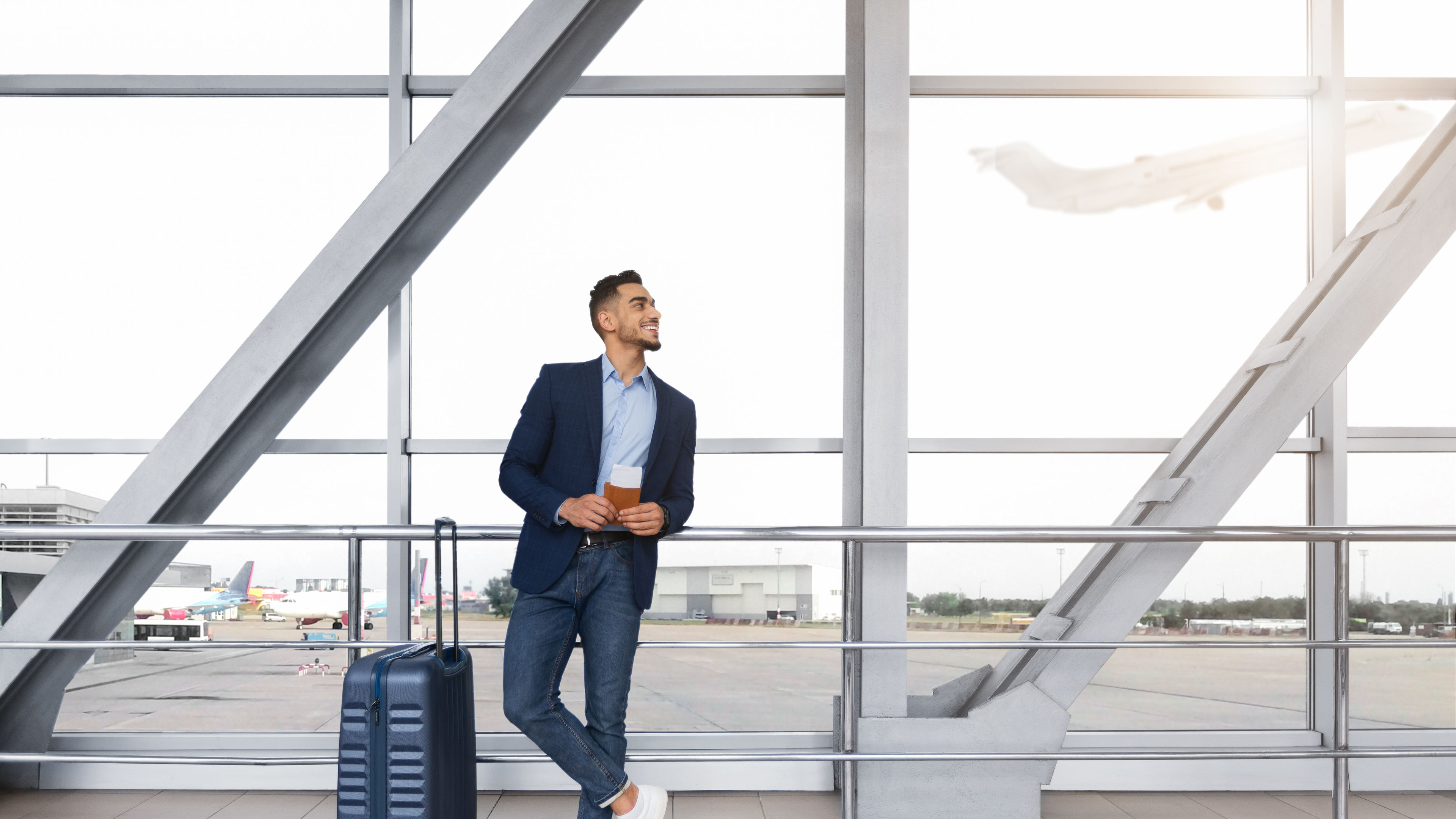 Handsome Arab Man Holding Passports And Tickets Standing With Suitcase In Airport