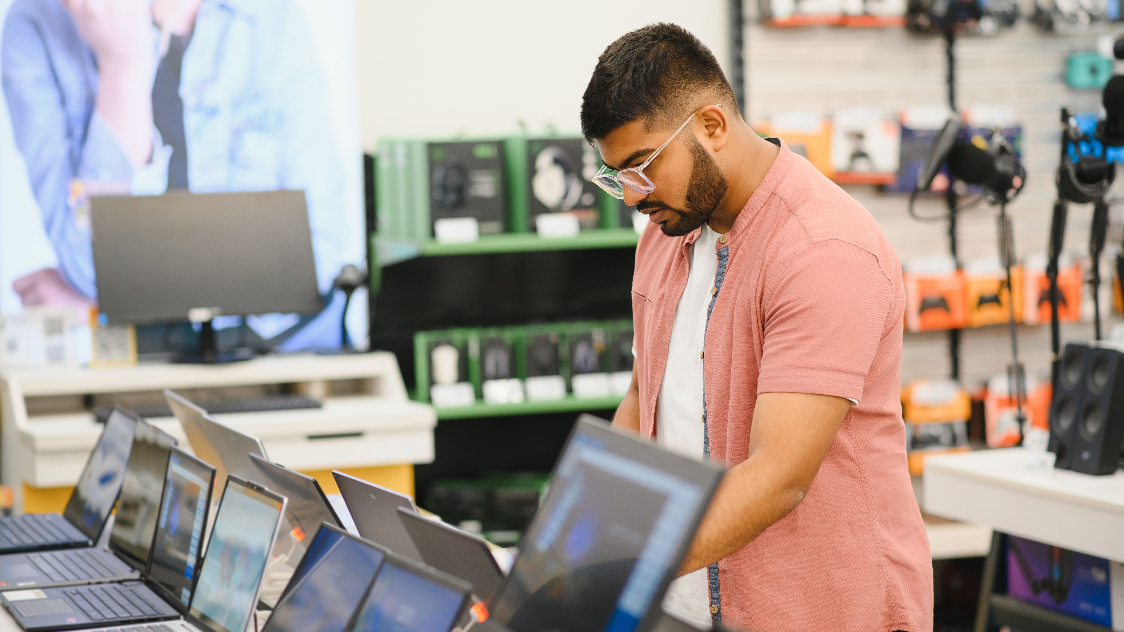 A young man checking a laptop in the gadget store.