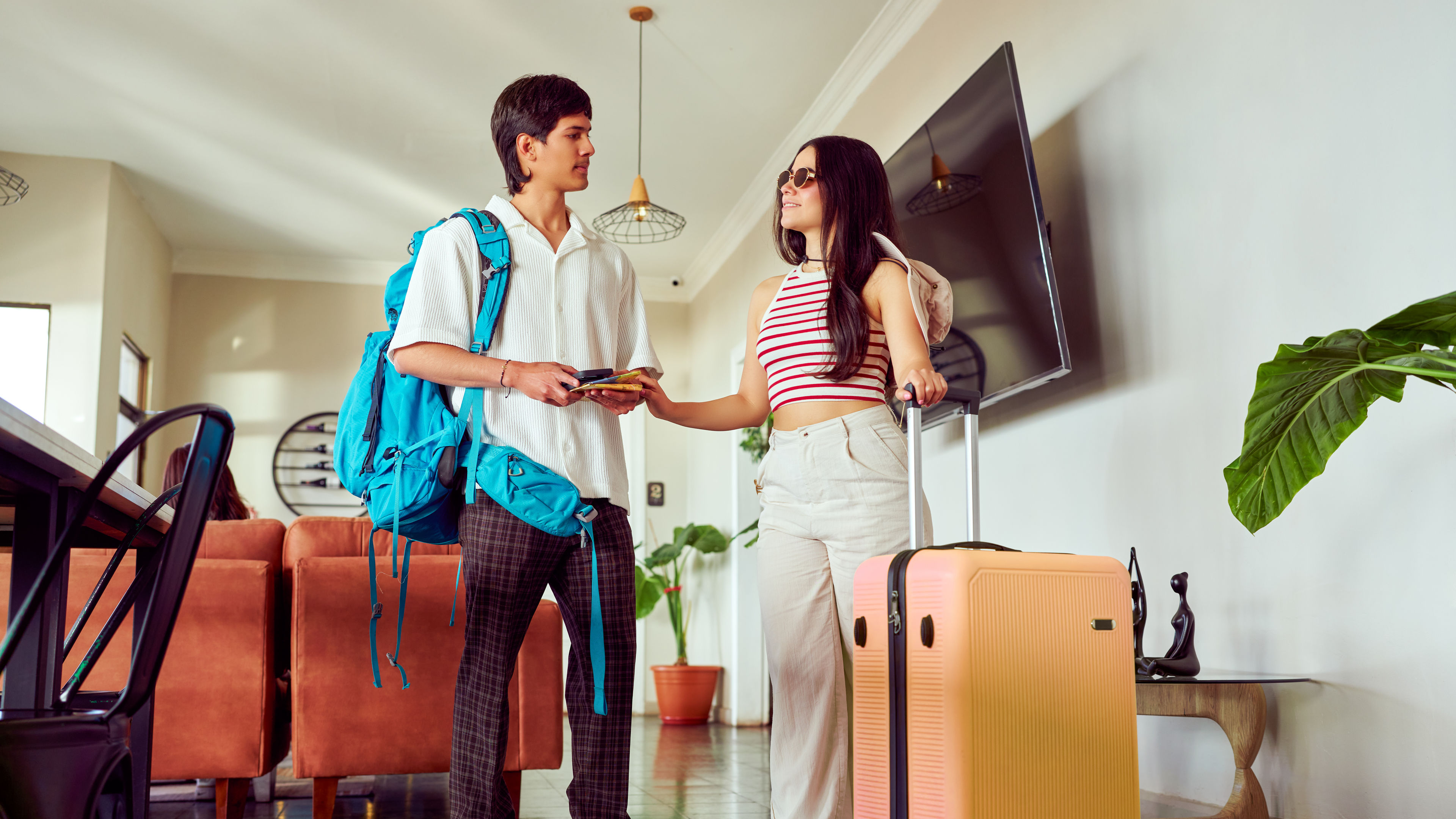 Tourists arriving at hotel lobby handing over passport to receptionist