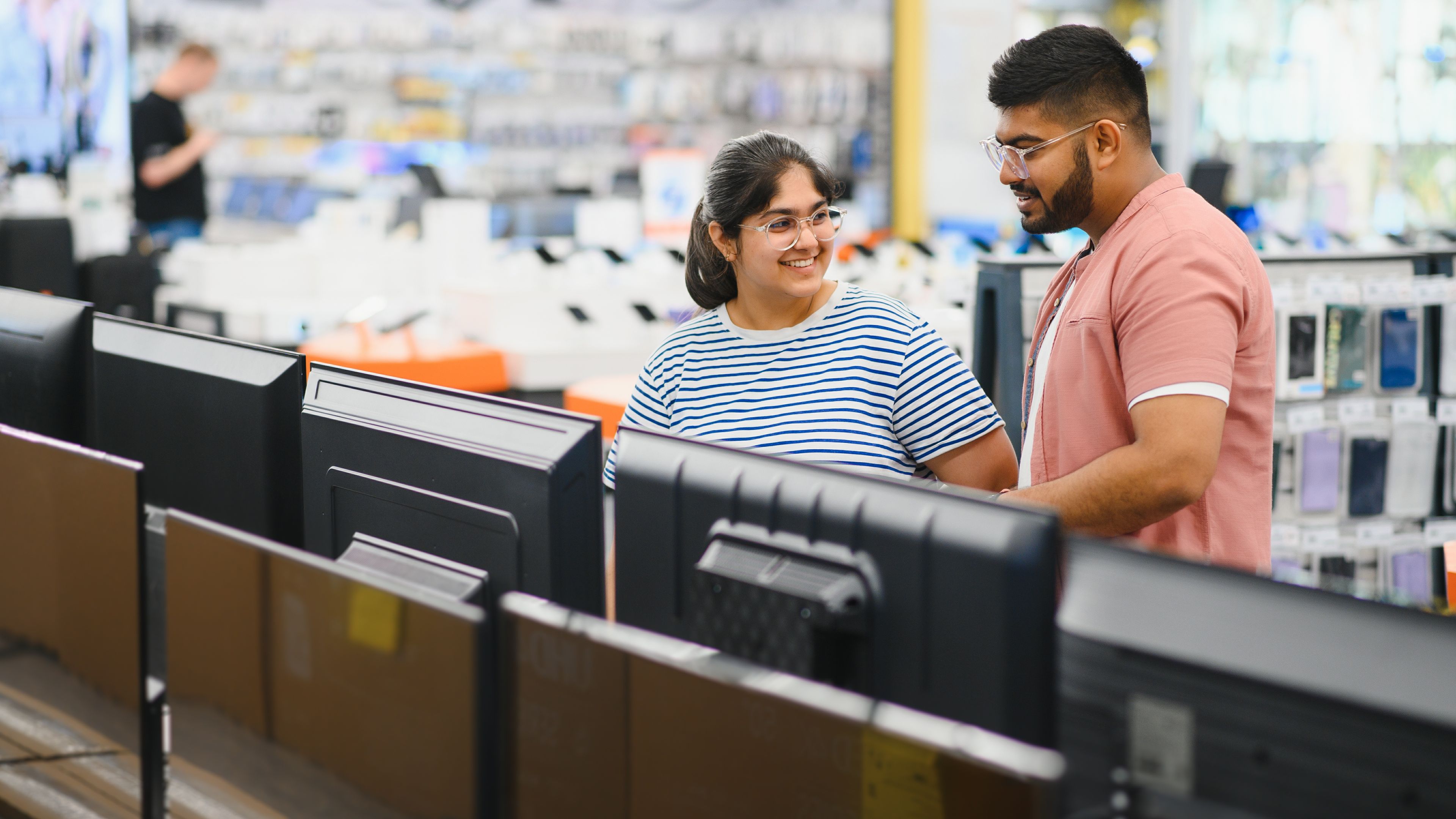 A man and a woman are buying laptops